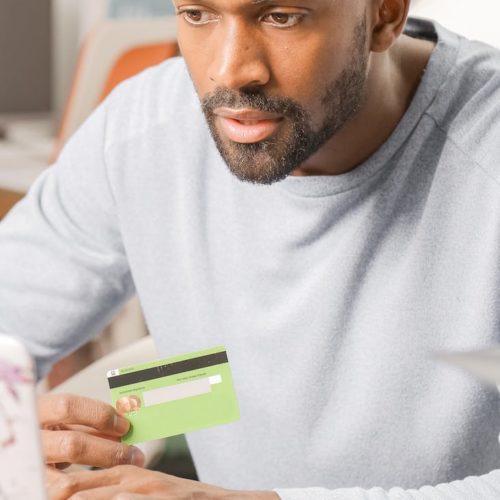 a bearded man holding a bank card